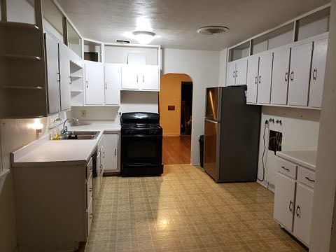Large kitchen with lots of cabinets and room for dining table.