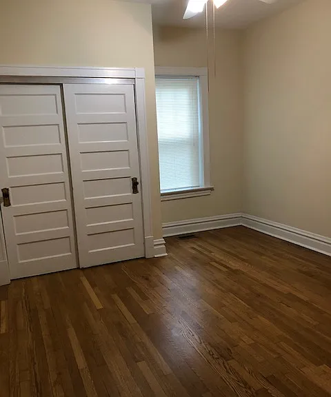Front bedroom, 2 windows with blinds, hardwoods, and ceiling fan