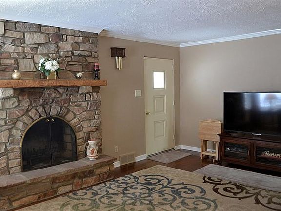 LIVING ROOM:  The floor to ceiling stone fireplace with raised hearth and mantle is the focal point of the living room.  There are hardwood floors throughout the home (with the exception of the kitchen).  The contemporary paint colors are accented by white crown molding.