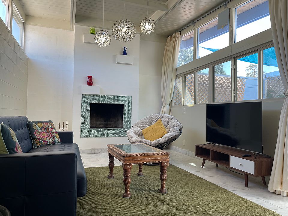High ceiling, stone tile floor, high windows facing east for morning light, large windows facing west, with private patio view. Functioning fireplace. Smart tv. Leather sofa that converts to a queen sized guest bed.