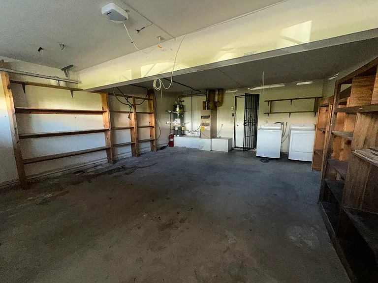 garage with lots of storage shelving and washing+Drying machines