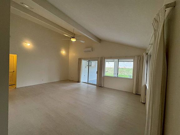 Living room, leading out to backyard and patio with split AC unit and ceiling fan