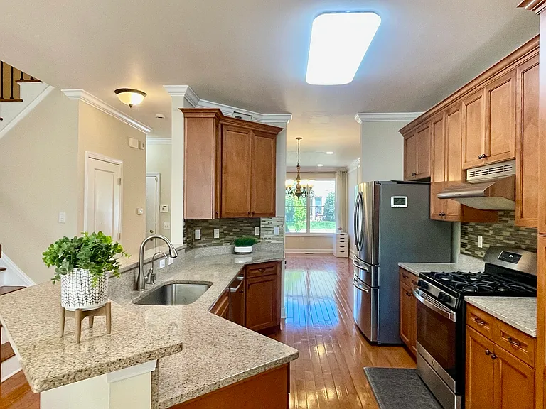 Bright and beautifully appointed kitchen featuring granite countertops, ample cabinetry, and open flow to the living spaces