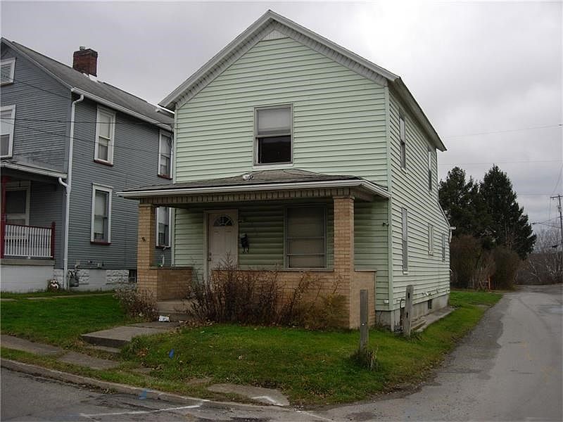 Front view of vinyl sided two story home with corner location.