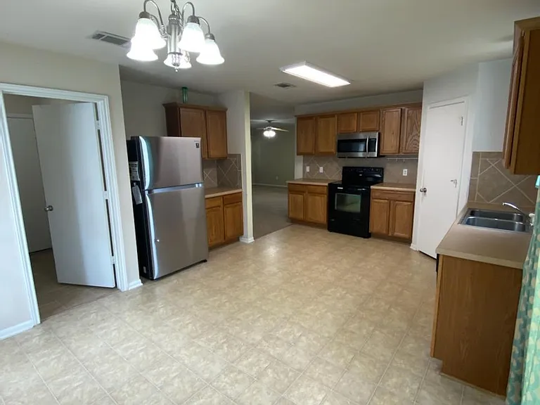 View of kitchen from back sliding door and dining area.