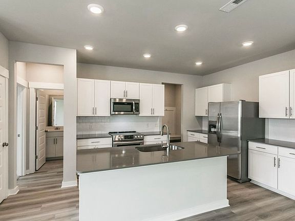 Stainless appliances. Countertops in unit are white Quartz.