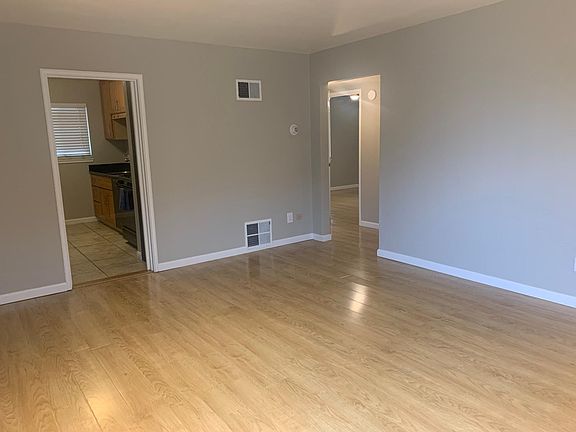 Living Room w. View of kitchen and hallway leading to bedrooms and bathroom.