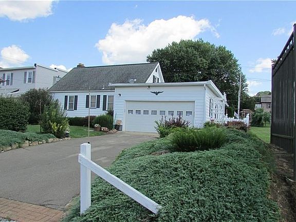 Exterior back of he house with 2 car garage and paved driveway.