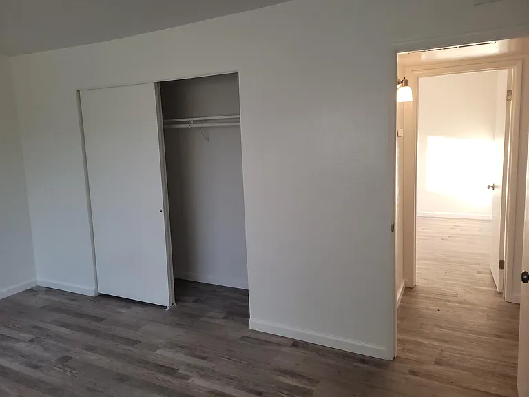 Bedroom 1 with large closet and view to hallway and Bedroom 2.