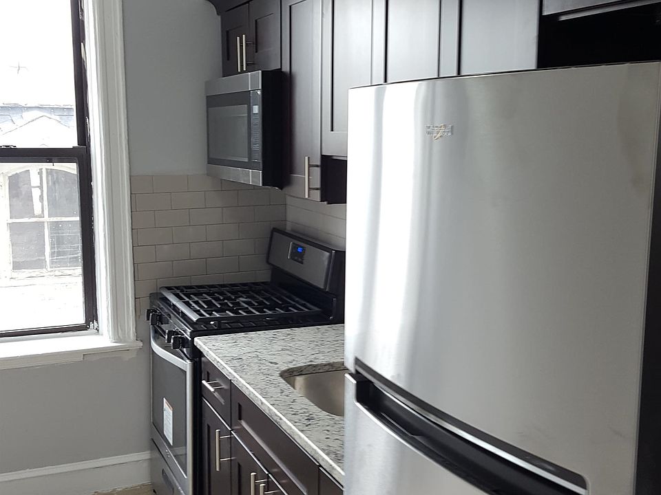 Kitchen. Granite countertop. Modern, stainless steel microwave, stove, and refrigerator.