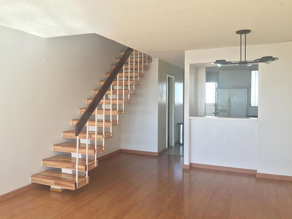 living and stairs way to second floor bed drums