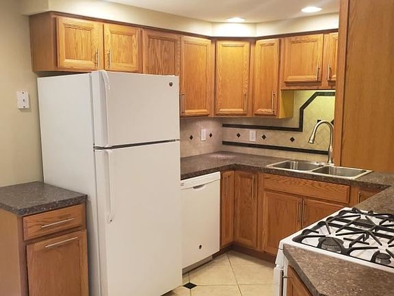 Kitchen area with refrigerator, dishwasher.