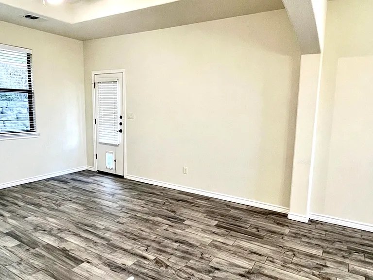Spacious living room area featuring a tray ceiling and direct backyard access