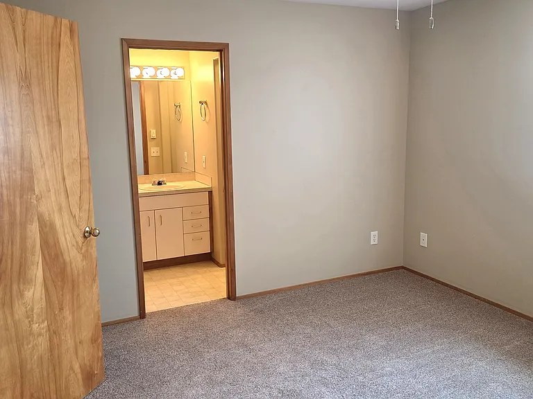 View into the primary ensuite bathroom from the interior of the primary bedroom.
