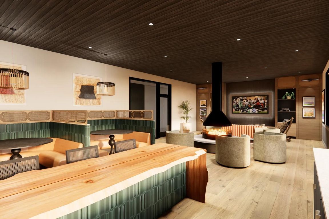 7th floor nature-inspired clubroom with catering kitchen, double-sided fireplace, and comfortable lounge seating.