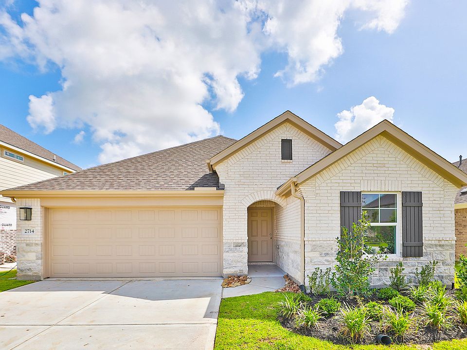 This Ellis Cove home boasts a sophisticated white brick exterior and elegant arched entry, nestled i