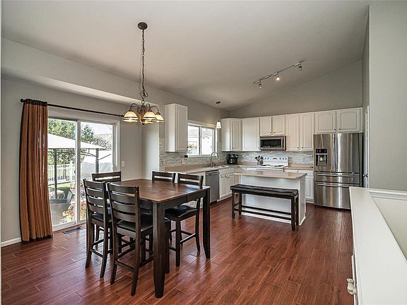Awesome entertaining space with Spacious Breakfast room, Wood Plank Tile Flooring, Center Island, Tile Backsplash, Refrigerator Stays, 42 inch cabinets and Brushed Nickel Hardware.