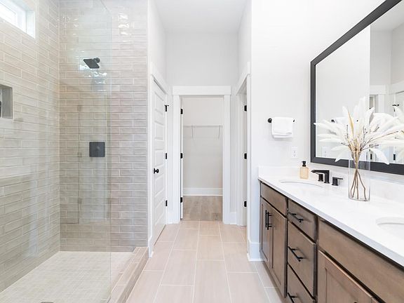 Gorgeous primary bathroom with a dual-sink vanity and luxe walk-in shower
