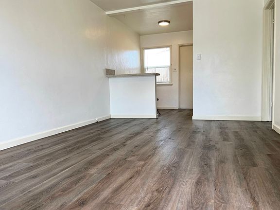 Living Room looking to Breakfast Bar, Dining Nook, Back Door & Kitchen Area. Luxury Vinyl Tile Plank Flooring.
