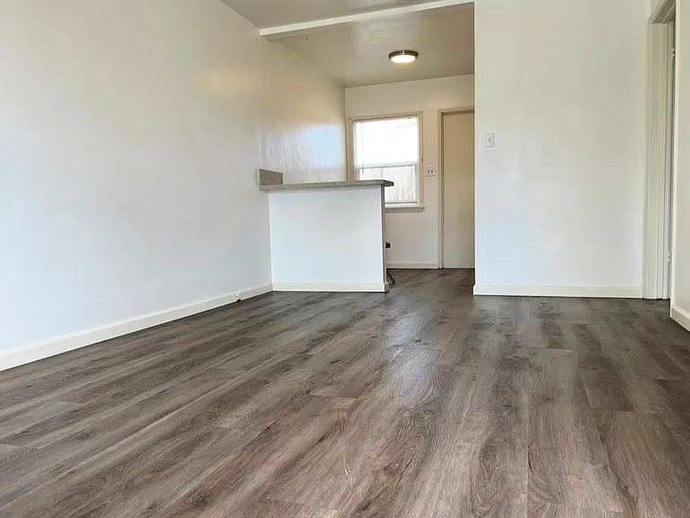 Living Room looking to Breakfast Bar, Dining Nook, Back Door & Kitchen Area. Luxury Vinyl Tile Plank Flooring.