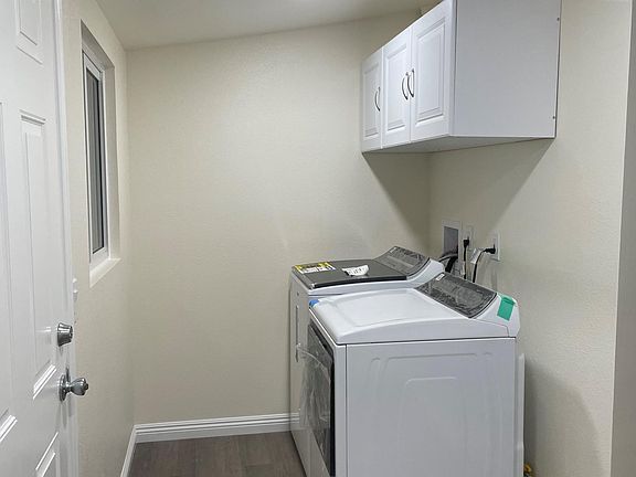 Other side of laundry room with new washer/dryer and cabinet.