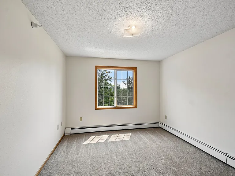 Step into comfort with this airy room at Mill Pond Apartments, featuring large windows that let in natural light and showcase stunning views. With ample space for your personal touch, this is the perfect canvas for your new home. Schedule a tour today!