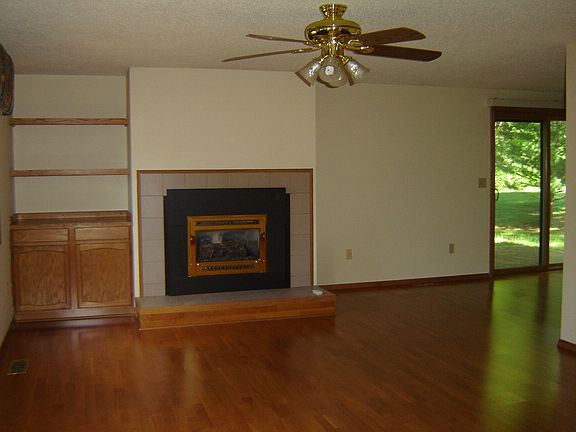 The spacious living room, open to the dining room, has wood floors, gas log fireplace, built-in shelves and cabinets.  Note:  The north windows in this room will be replaced soon.