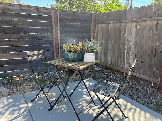 Spacious private fenced backyard with concrete patio, room for outdoor cooking, dining and lounging, grow flowers and edibles.