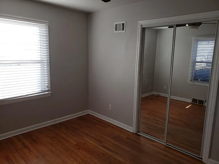 First bedroom again showing the mirrored sliding closet doors.