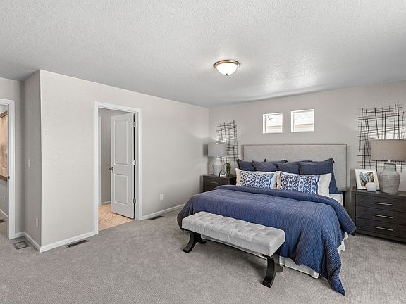 A view of the primary bedroom and entrance to the primary bathroom