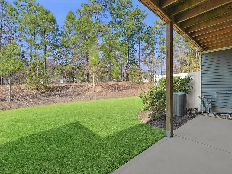 Patio walkout to private yard, featuring partition for added privacy without sacrificing openness