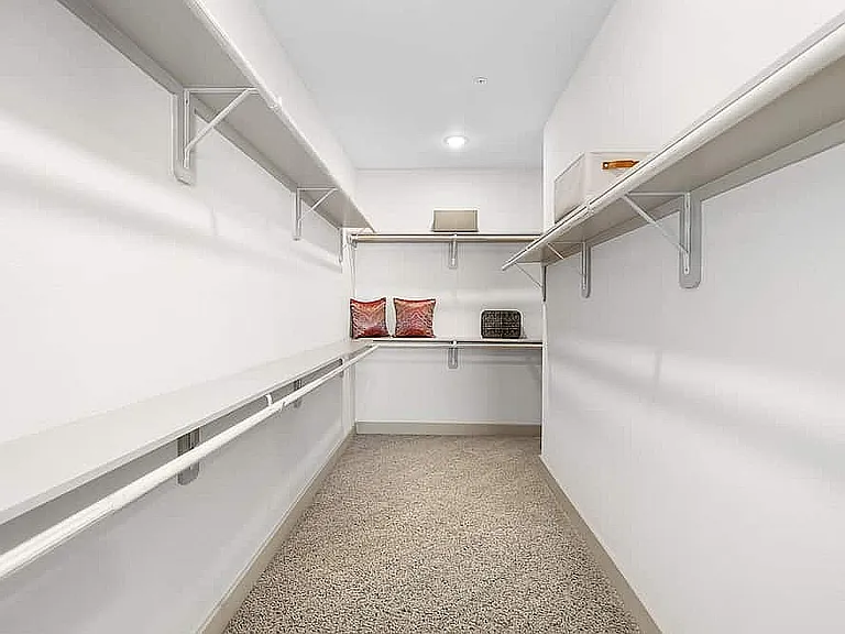 Explore your dream walk-in closet, designed with generous storage and elegant touches.