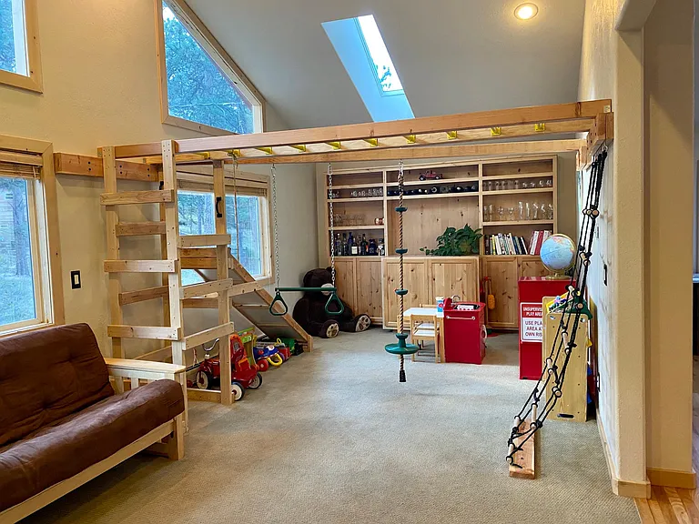Optional jungle gym set up in this bonus room off of the kitchen with climbing rope ladder, monkey bars, climbing tower, slide, rope swing, and gymnastics, trapeze bar and triangle rings.