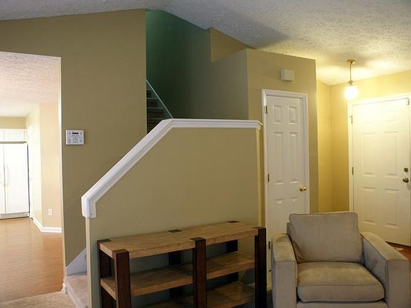 Living room, entryway, stairs up to bedrooms and entry to ki