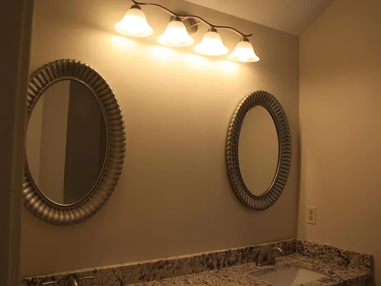 Spacious master bathroom with double vanity. new light fixtures, granite, mirrors, and faucets