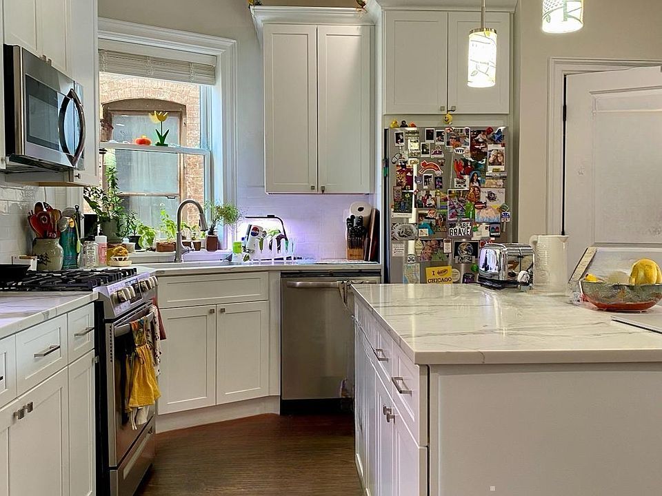 Kitchen with stainless steel appliances, white cabinets, and granite counter