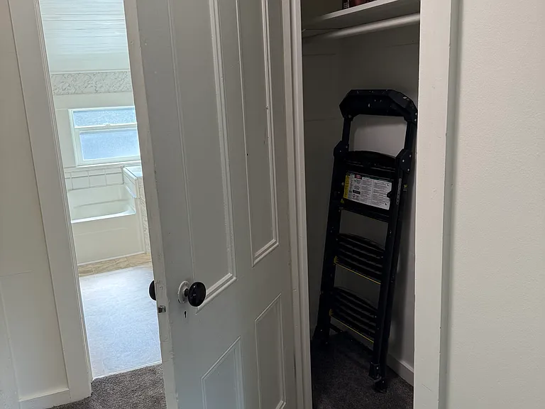 hall closet with bathroom beyond