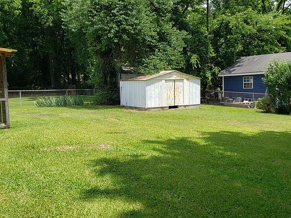 Fenced back yard with storage building
