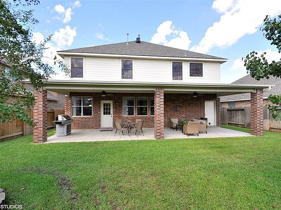 And this is what you know you want! Full length covered back patio. Two ceiling fans, plenty of space for multiple gathering areas. Notice the door to the right which accesses the 3rd bay of the garage.