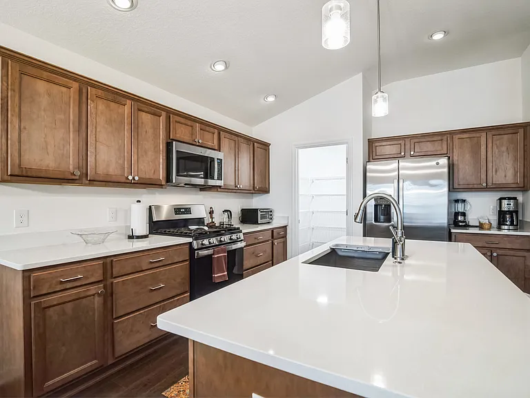 A Chef's Delight in a Kitchen with Cabinet Storage and a Walk-in Pantry with Storage for Equipment and Food.