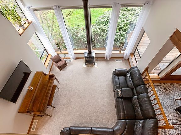 Bright and cheery living room from upstairs landing.  Large windows face back yard.  Dining room is to the right.