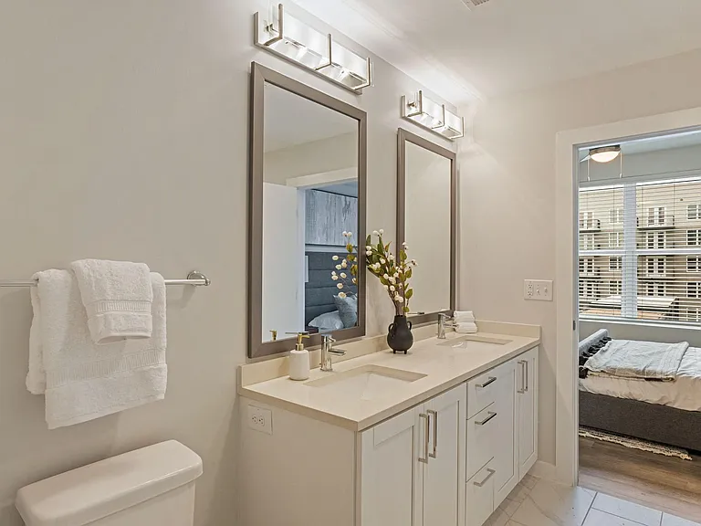 Polished Bathroom With Quartz Countertops and Pearl Paneled Cabinets