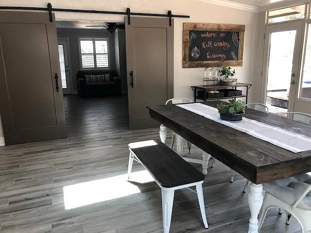 Barn doors leading into living room with man door leading to one of two back patios.