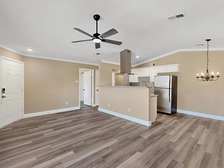Unfurnished living room featuring ornamental molding, light wood-style floors, a ceiling fan, recessed lighting, and lofted ceiling