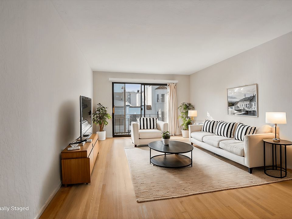 Living room with a large window , furnished with sofa, coffee table, and a television