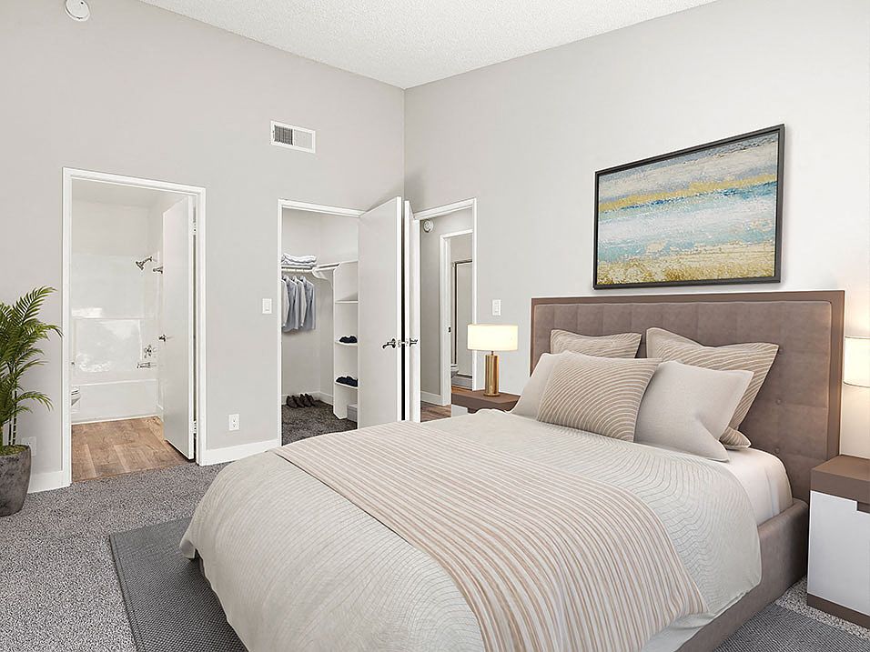 Carpeted bedroom with private bathroom.