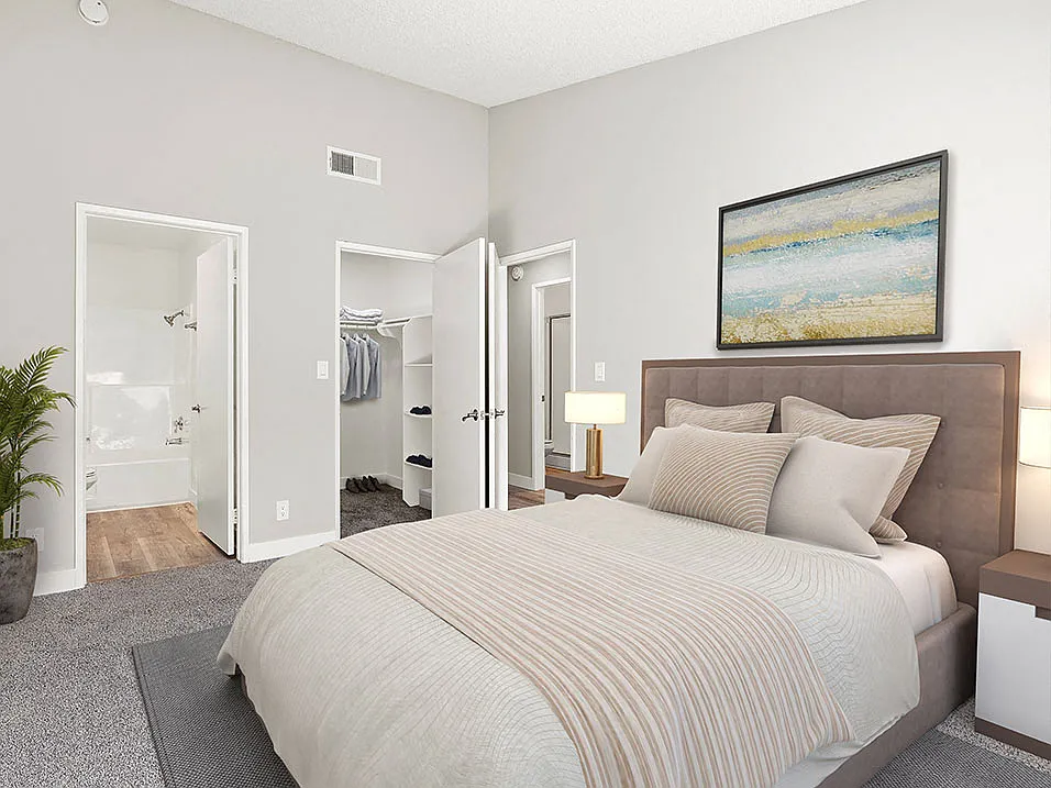 Carpeted bedroom with private bathroom.