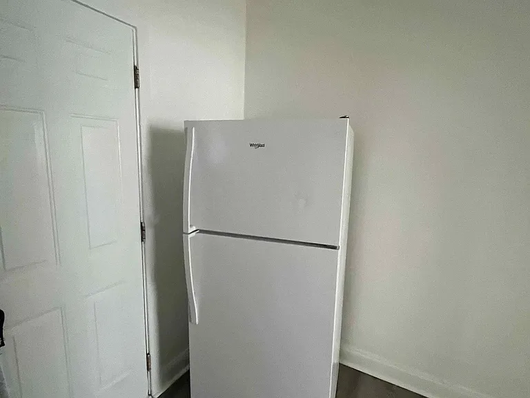 Kitchen area includes a full-size top-freezer refrigerator, offering convenient cold storage for everyday meal prep.