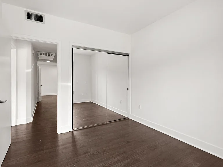 Bedroom with Mirrored Closet and Vinyl Flooring