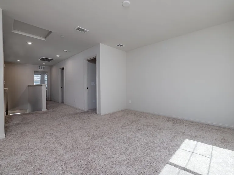 Spacious upstairs loft area facing south, offering access to the two bedrooms, master suite, and laundry room. Perfect as a family lounge, playroom, or home office with plenty of natural light and an open, airy layout.